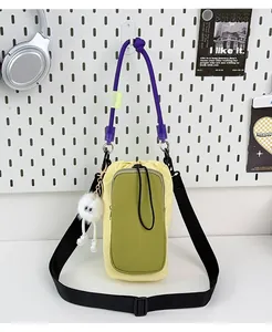 Front view detail of a dopamine-colored lightweight small messenger and phone bag