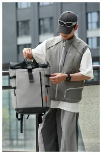 Outdoor lifestyle shot of a men's waterproof grey Oxford backpack with large capacity