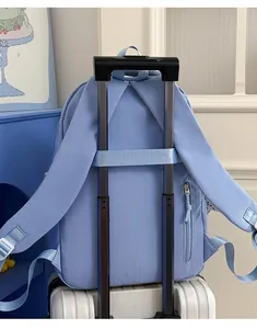 Detail of the trolley sleeve on a light blue backpack attached to suitcase luggage handle.