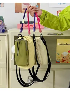 Hand holding vibrant dopamine-style crossbody phone bags with unique water bottle pouch.