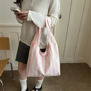 Casual pink and white striped underarm tote bag with subtle bow tie patterns for women