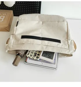 Detail view showing the large storage capacity of this cream utility messenger bag