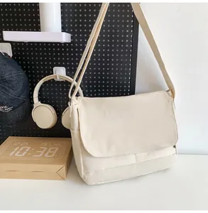 Detail view of a beige corduroy messenger bag hanging against a stylish studio background