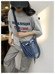 Photo lifestyle d'un sac seau en jean bleu pour femme avec bandoulière réglable chic