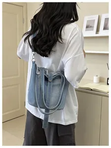 Vue arrière d'un sac seau en jean décontracté porté en bandoulière sur un t-shirt