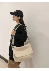 Asian female model wearing a large Japanese style beige canvas messenger bag daily