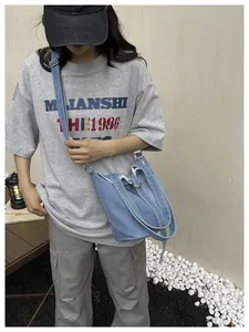 Sac seau en jean bleu élégant porté en bandoulière pour un look décontracté chic