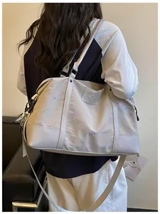 Detailed view of the grey large capacity travel bag being worn by a person from the back.