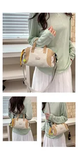 Detailansicht der Damen-Umhängetasche in Beige und Khaki mit sportlichen Anhängern