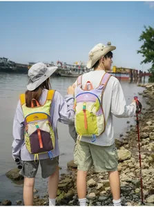 Zwei Wanderer tragen lebendige, farbenfrohe Trekking-Rucksäcke im Freien am Fluss