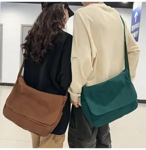 Rear view of a couple wearing large capacity green and brown canvas messenger bags.