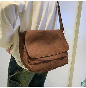 Detailed view of a brown corduroy messenger bag worn across the shoulder for daily use.