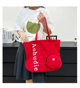 Red washed canvas tote bag being held by a model to show its large size and capacity