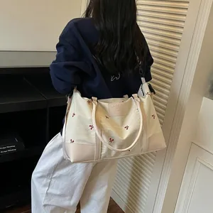 Cream large capacity travel bag with red embroidery and shoulder strap