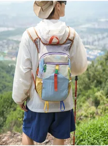 Leichter Wanderrucksack in buntem Design auf dem Rücken in einer Berglandschaft
