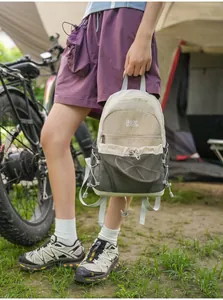 Detail van een kleurblok mini-rugzak in de hand gehouden in een outdoor kampeerscenario