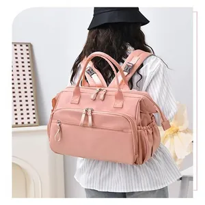 Rückansicht einer Frau mit einem großen rosa wasserdichten Windelrucksack für Mütter.