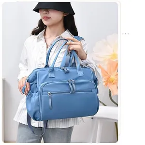 Asiatisches Model mit großer blauer wasserdichter Wickeltasche mit mehreren Reißverschlüssen