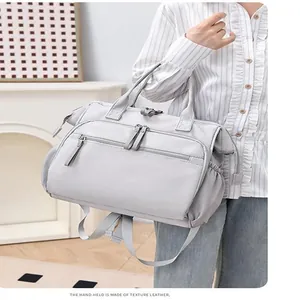 Detailansicht der grauen wasserdichten Wickeltasche mit Ledergriffen