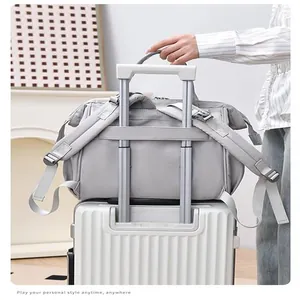Detailansicht der grauen wasserdichten Wickeltasche mit Kofferhülle am Koffergriff