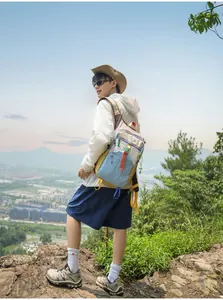 Ein Wanderer mit einem bunten Dopamin-Wanderrucksack auf einem Bergpfad im Freien stehend