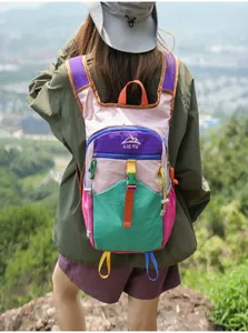 Detailansicht eines bunten Patchwork-Wanderrucksacks mit Berglogo-Stickerei auf dem Berg