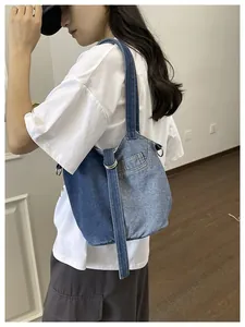 Sac seau en jean patchwork décontracté porté comme sac à bandoulière par un mannequin