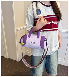 Frau mit stilvoller lavendel- und lilafarbener Boston-Handtasche und Tennisball-Anhänger
