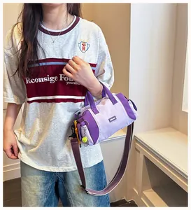 Lifestyle-Nahaufnahme einer lila Sport-Bowling-Handtasche, die von einem Model getragen wird