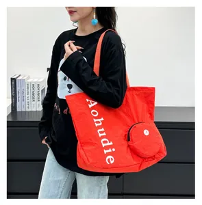 Detail view of a stylish orange large-capacity washed cloth tote bag with a small pouch