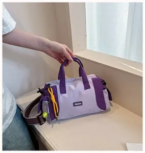 Nahaufnahme einer trendigen violetten Sporttasche, die an einem Fensterbrett gehalten wird
