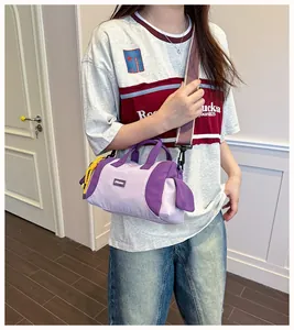 Detailansicht einer stylischen lila Nylon-Mini-Boston-Tasche, die von einem Modell getragen wird