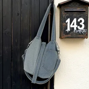 Sac seau élégant en denim patchwork pour femmes, accroché sur un fond de rue vintage.