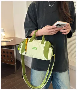 Lifestyle-Ansicht der trendigen grün-cremefarbenen Sport-Zylindertasche für Damen