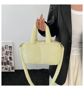 Modern light yellow quilted puffer handbag with a soft padded strap for everyday style