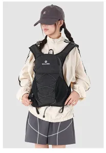 Model wearing a black grid hydration backpack for cycling and hiking outdoors
