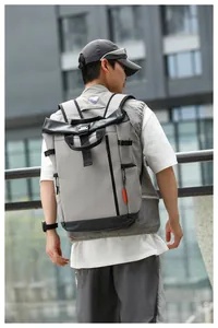 Outdoor view of a grey water-repellent Oxford backpack worn by a man in an urban setting