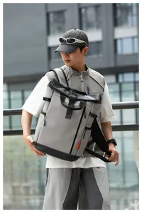 Detail view of water-resistant gray Oxford cloth men's backpack shown in urban setting