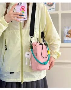 Model wearing a pink dopamine-style crossbody phone bag with teal rope handle