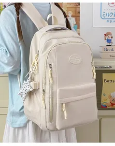 Minimalist beige Japanese style student backpack worn by a girl in a cozy bedroom setting.