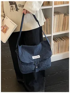 Borsa a tracolla in tela a scacchi blu per studenti in un ambiente da biblioteca d'epoca