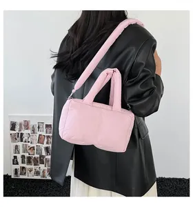 Detailed side view of a stylish pink puffer handbag worn with a black leather jacket