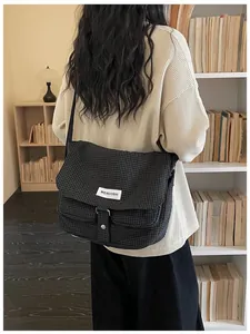 Vista posteriore di una persona con una borsa a tracolla in tela a scacchi