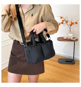 Stylish black quilted puffer bag held by a model in a cozy, warm lifestyle setting