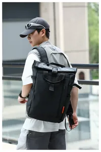 Rear view of a man wearing a black water-resistant Oxford backpack in urban setting