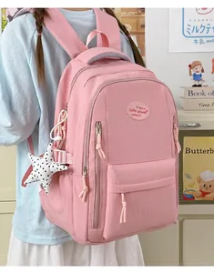 Close-up of a pink water-repellent student backpack with a cute star charm detail