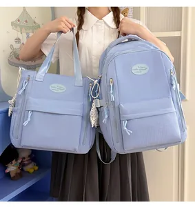 Large capacity light blue student backpack and matching tote bag set shown with model