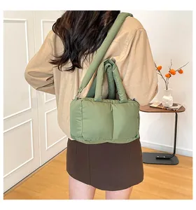 Stylish green quilted puffer tote bag shown as a casual crossbody bag on a model