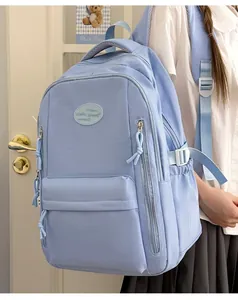 Light blue minimalist water-resistant school backpack shown on female model back view