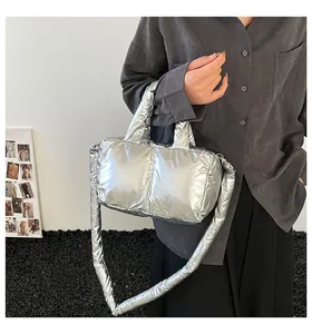 Silver metallic puffer handbag detail showing quilted texture and long shoulder strap